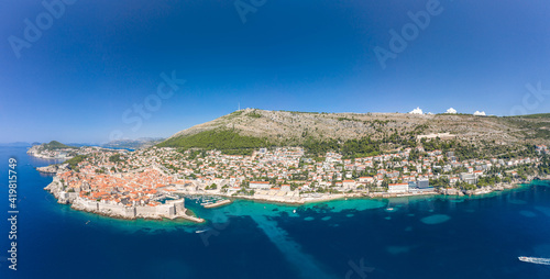 Aerial panorama drone shot of Dubrovnik old town coastline by Adriatic sea in Croatia summer noon
