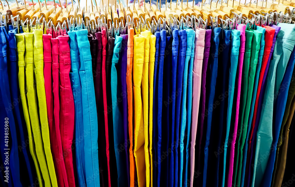 colorful trousers with hanger on rack , cloths shop in shopping mall .	
