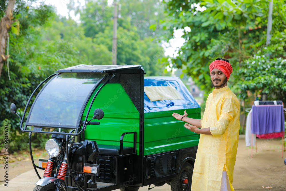 Young indian man standing with garbage van Young indian man standing with garbage van