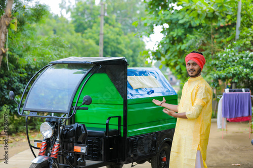 Young indian man standing with garbage van