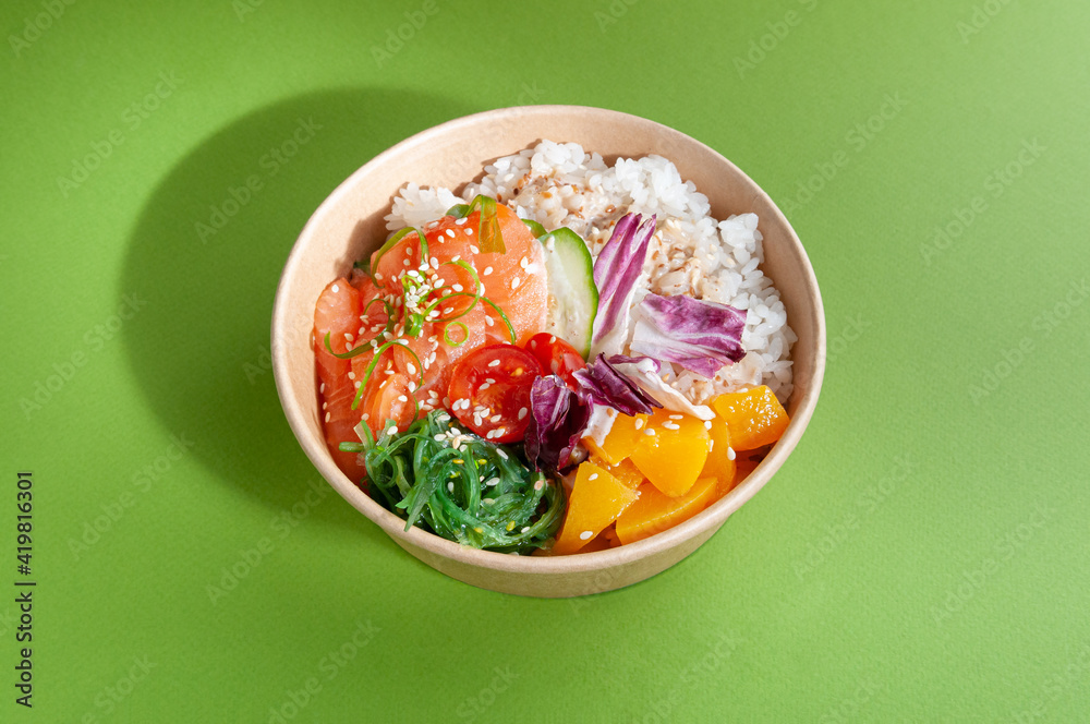 Poke with salmon and vegetables. In a food delivery plate. Close-up. view from above. Isolated.