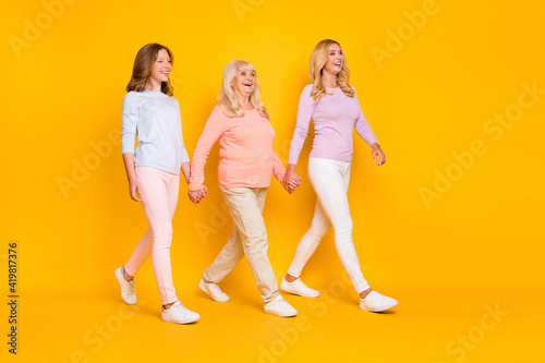 Full size profile photo of optimistic three woman grand mom daughter go wear pastel cloth isolated on yellow background