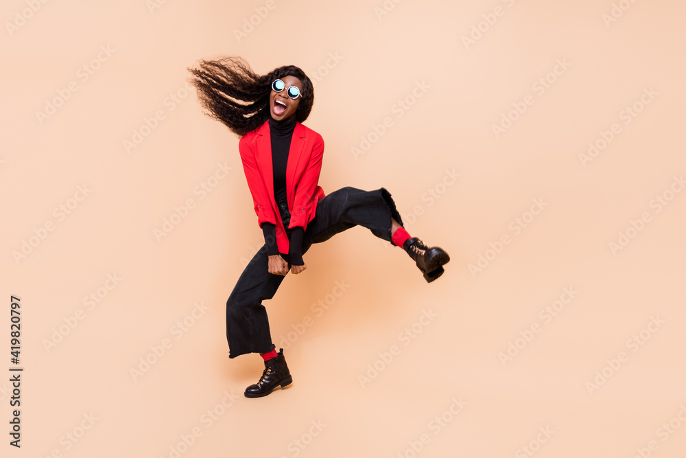 Full length photo of crazy funky afro american lady wear sunglass ride isolated on beige color background
