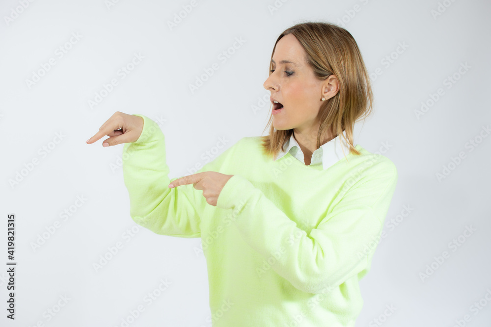 Smiling woman pointing finger side. Isolated portrait on white. Smiling woman pointing finger side. Isolated portrait on white.