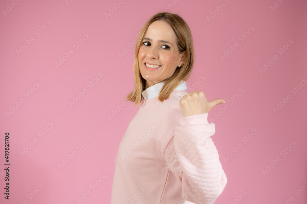 Close up side profile photo beautiful amazing pretty lady arm hand thumb finger indicate empty space wear casual sweater isolated pink background Close up side profile photo beautiful amazing pretty lady arm hand thumb finger indicate empty space wear casual sweater isolated pink background