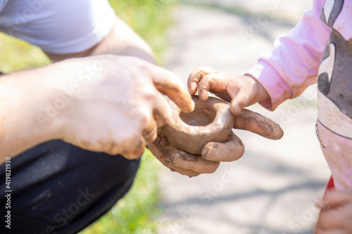 Foto dad and toddler make clay outside on a sunny day close-up, no face