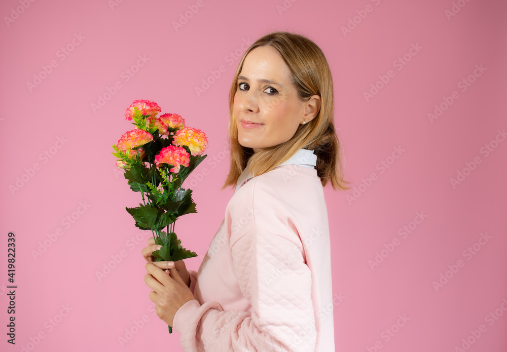 Valentines day, romance, celebration and beauty concept. Charming elegant and feminine young woman receive flowers, holding beautiful bouquet and laughing joyfully, pink background Valentines day, romance, celebration and beauty concept. Charming elegant and feminine young woman receive flowers, holding beautiful bouquet and laughing joyfully, pink background