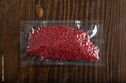 Crushed and dried raspberry flakes in vacuum sealed plastic bag