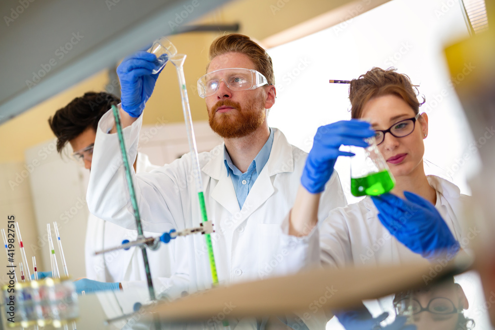 Serious clinicians studying chemical elements in laboratory
