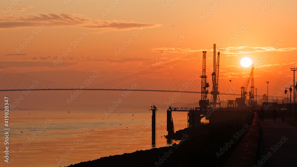 Lever de soleil doré avec le port d'Honfleur et le pont de Normandie à contre jour