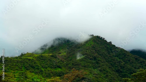 Lockdown: Wispy Clouds Slowly Move Around A Lush Tree Covered Hill On Cloudy Day