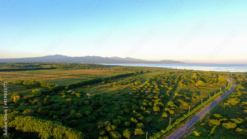 Aerial panoramic View of a scenic Highway surrounded green field Landscape during a summer morning
