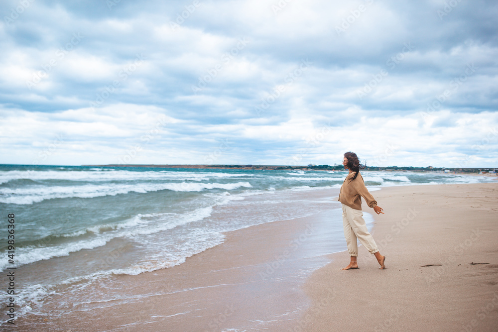 Young woman on the beach in the storm Young woman on the beach in the storm