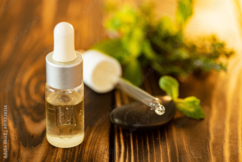 Bottle of essential oil with fresh herbal Bottle of essential oil with fresh herbal