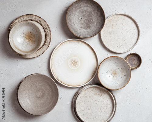 Valokuvatapetti handmade ceramics, empty craft ceramic plates on light background top view