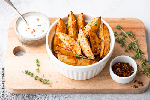 baked potato wedges with sauce on a light background