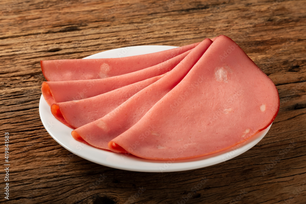 Plate with sliced mortadella on the table. Plate with sliced mortadella on the table.