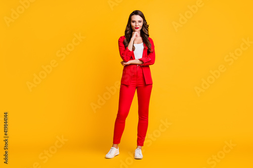 Full length photo of cute classy lady finger chin wear red suit blazer pants sneakers spectacles isolated yellow color background