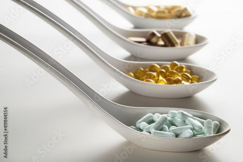 Four spoons filled of supplements diffrent color and shape. As a concept of natural medicines. Preventive medicine.  photo