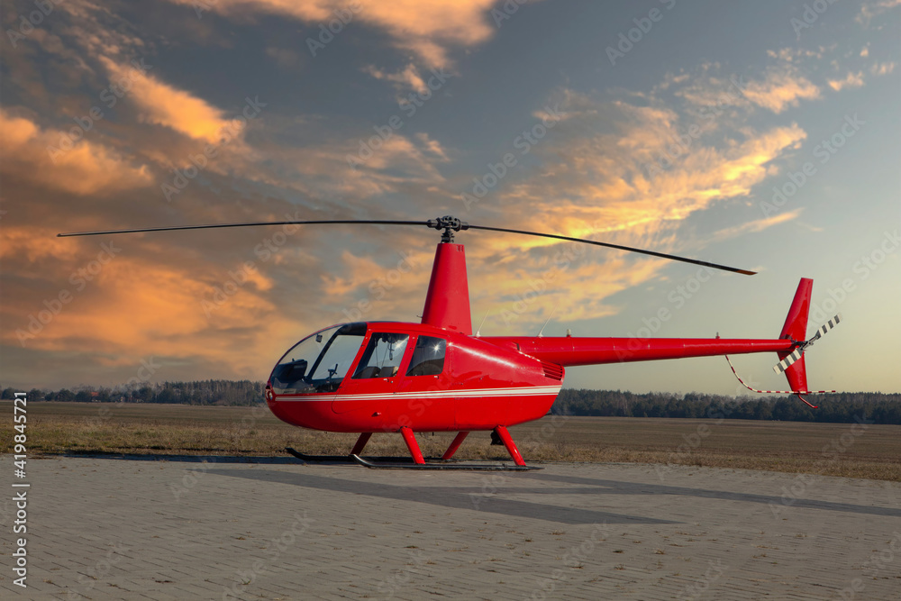 RED Helicopter Robinson R44 raven II - sunset at take-off site. - obrazy, fototapety, plakaty 