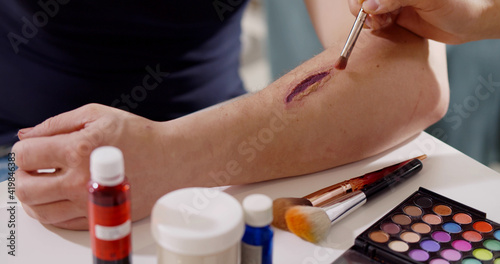 Close up of professional making fake wound makeup special effect on arm