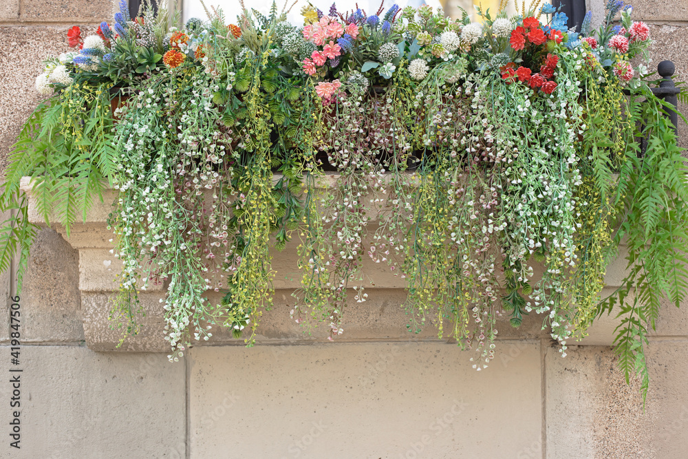 Naklejka premium flowers on the balcony, home decoration with plants, artificial plants for interior