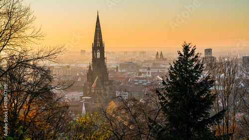 Germany, Freiburg im Breisgau, Magical orange sunset sky above skyline of the beautiful city and muenster on cold winter day