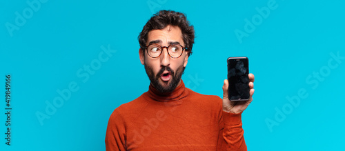 young crazy bearded man confused expression. smart phone concept
