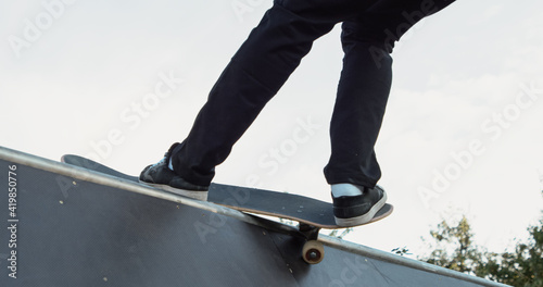 Young male adult skateboarding halfpipe miniramp grinding and makes tricks