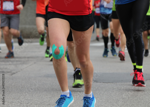 runner during the foot race with the knee bandage to avoid muscl