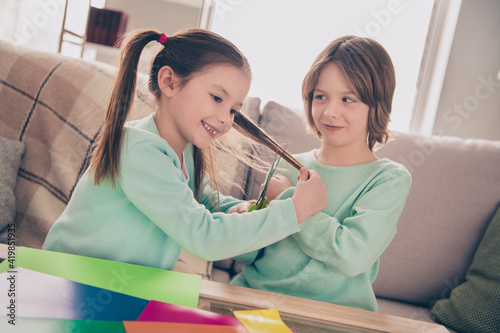 Tablou pe pânză Photo of little pupils sit on couch guy look interested hand hold scissors cutti