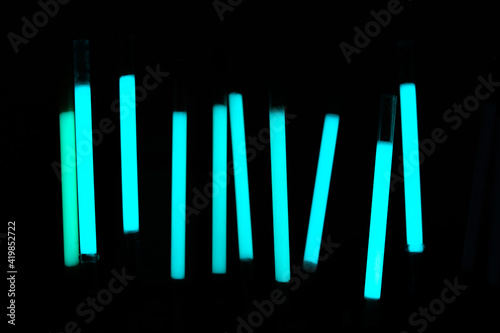 Demonstration of the work of fluorescent sticks in the dark. Bright blue on a dark background