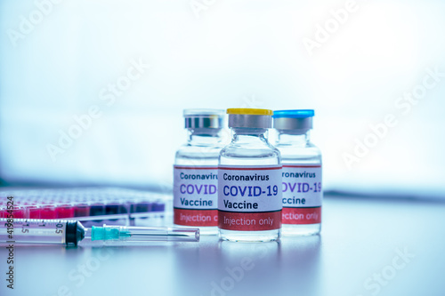Coronavirus vaccine bottles with syringe on laboratory table