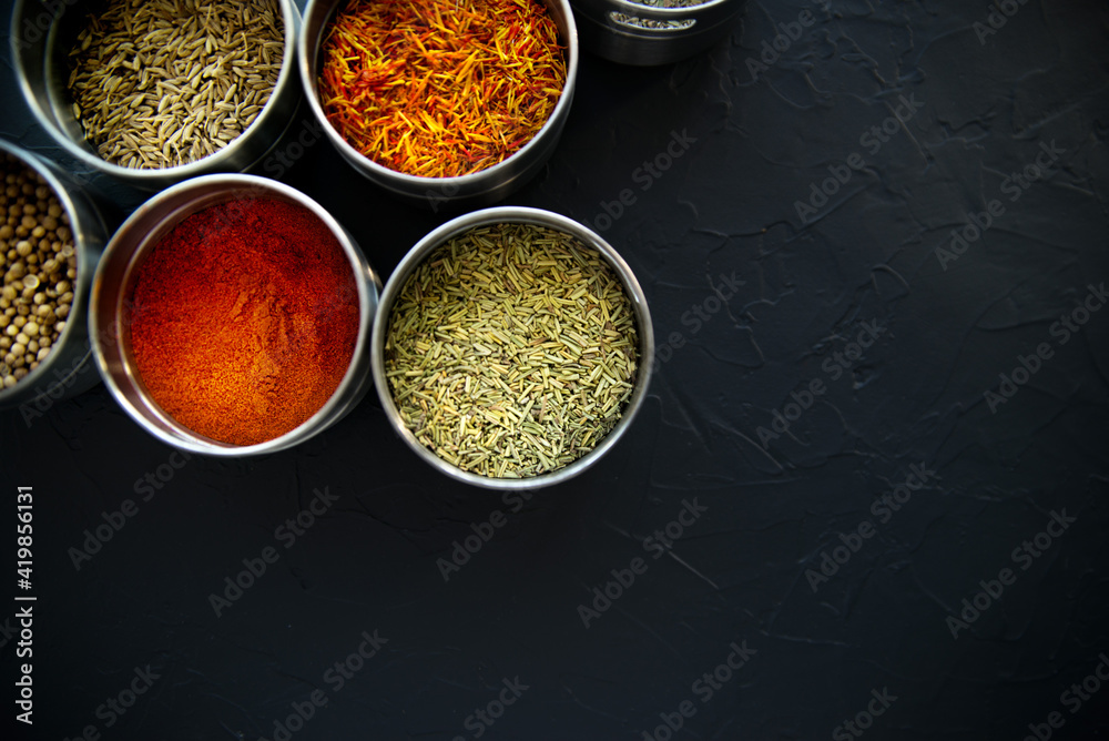 large set of Indian spices and herbs. On a black board.