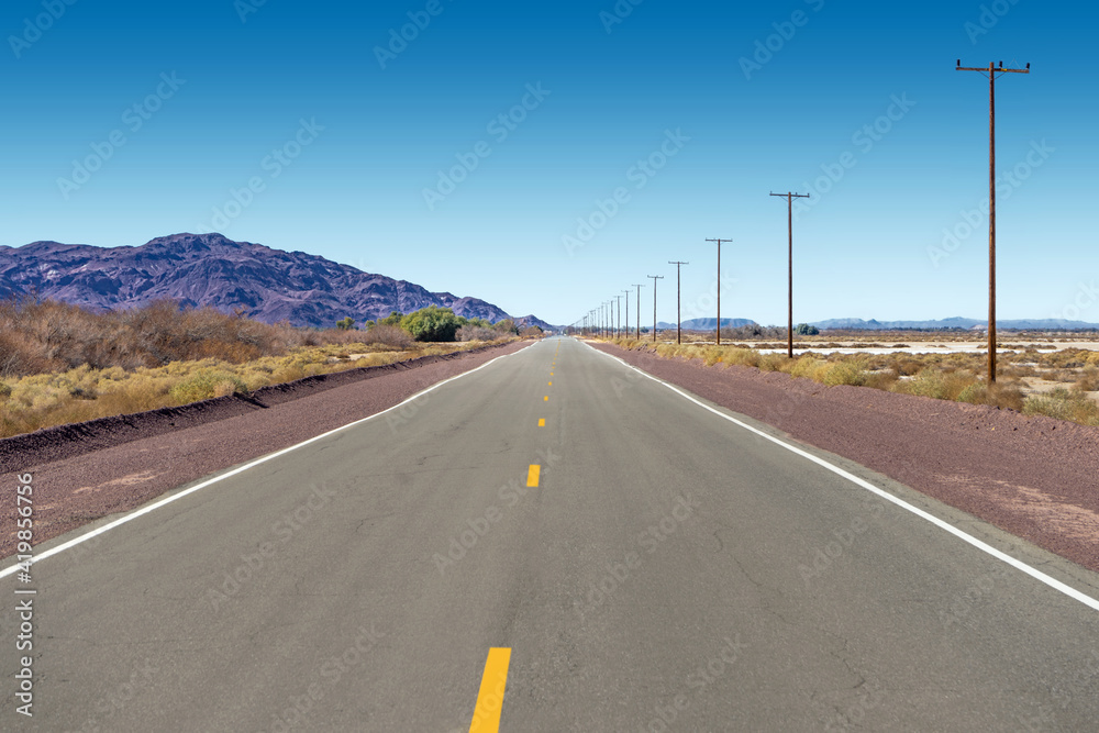 Vanishing flat road on Route 66 in the Mojave Desert in California