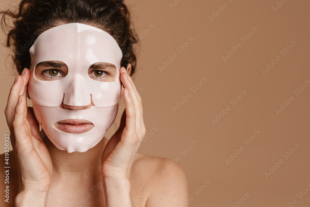 Half-naked woman looking at camera while posing in facial mask Half-naked woman looking at camera while posing in facial mask