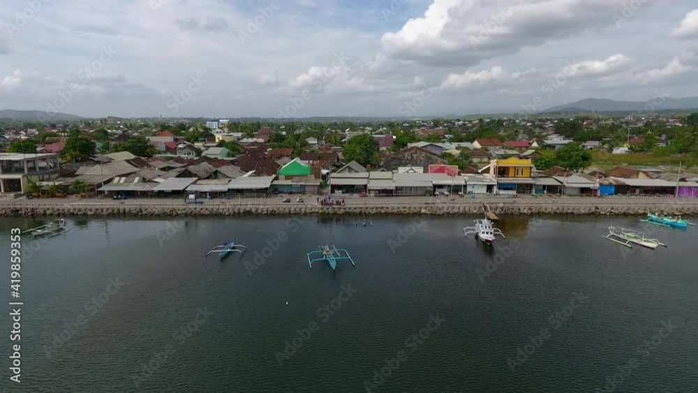 drone fly over Jempol Beach, Sumbawa island, Indonesia. traditional fisherman boat and little rural village unique travel destination drone fly over Jempol Beach, Sumbawa island, Indonesia. traditional fisherman boat and little rural village unique travel destination
