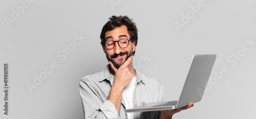 young crazy bearded man. thinking or doubting expression. laptop concept