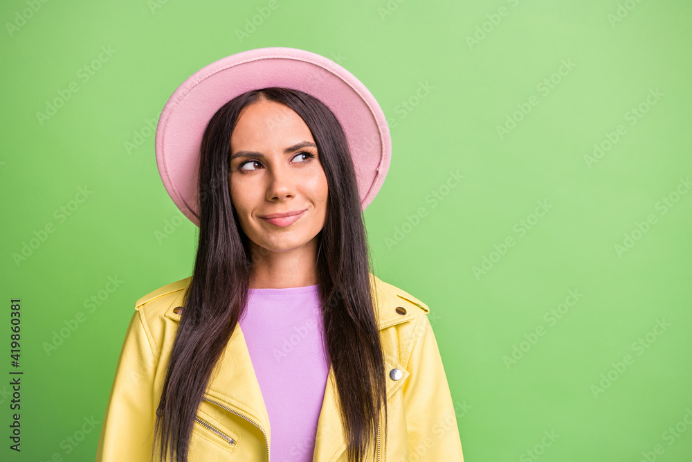 Photo portrait of curious brunette looking at blank space wearing hat jacket isolated on bright green color background Photo portrait of curious brunette looking at blank space wearing hat jacket isolated on bright green color background