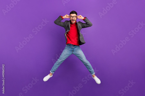 Full size photo of optimistic nice brown hair man jump wear spectacles sweater isolated on purple background