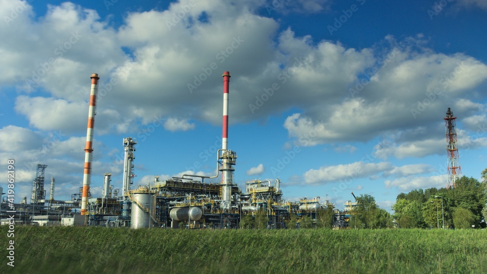 Oil refinery in sunny beautiful weather with clouds in background Oil refinery in sunny beautiful weather with clouds in background