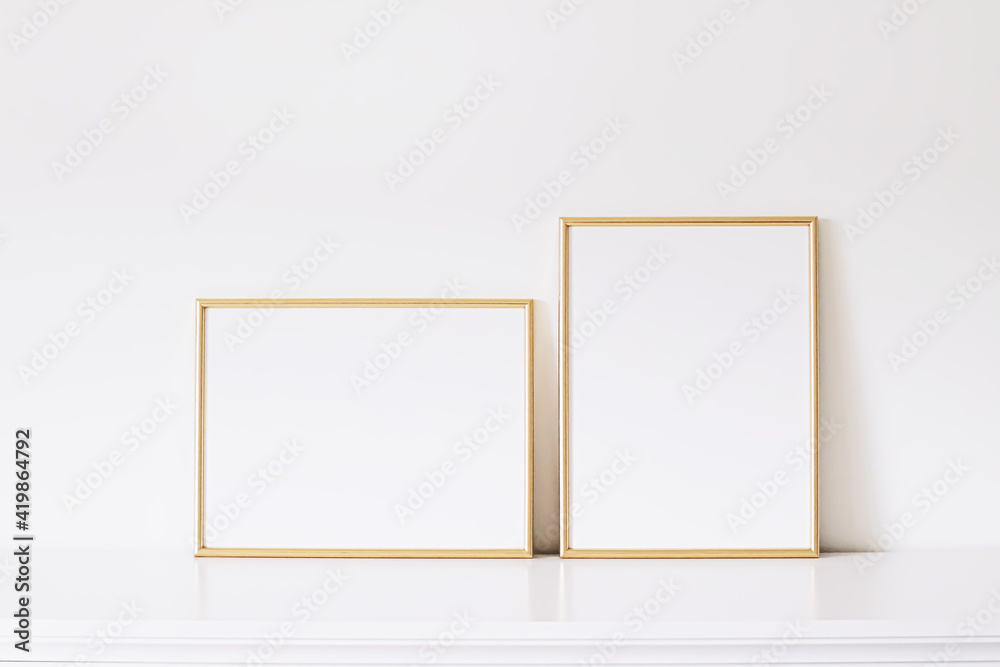 Two golden vertical and horizontal frames on white furniture, luxury