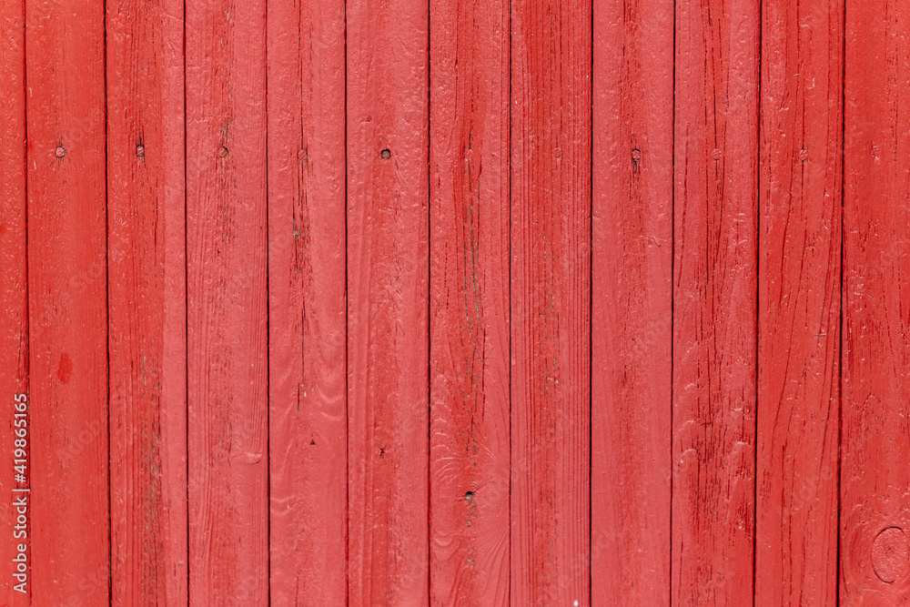 Weathered dark bright scarlet red painted vertical wooden plank wall with painted nails Weathered dark bright scarlet red painted vertical wooden plank wall with painted nails