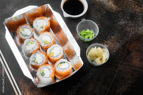 Set of sushi rolls in delivery food box, on old dark rustic background , with copyspace  and space for text