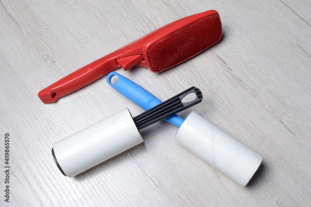 brushes for cleaning clothes. sticky and a bristled brush, lie on a light-colored countertop.