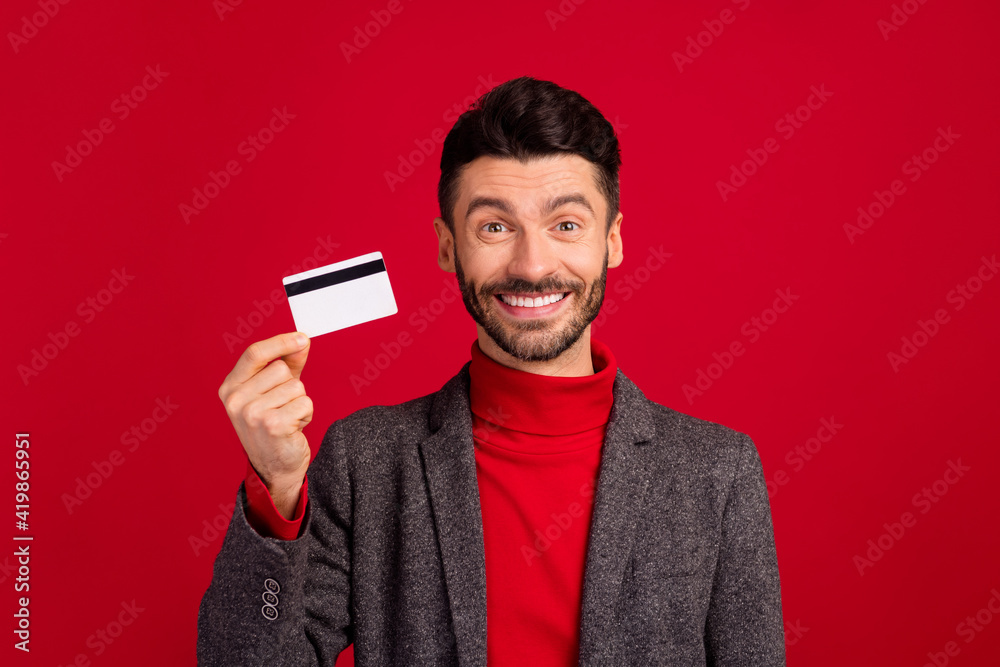 Photo of optimistic nice grey brown hair man with card wear red sweater jacket isolated on vivid color background Photo of optimistic nice grey brown hair man with card wear red sweater jacket isolated on vivid color background