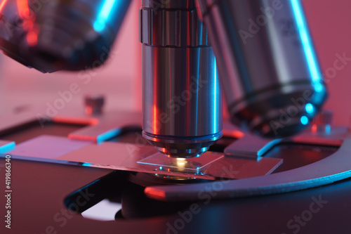 Toned photo of a backlit microscope lens in a science laboratory