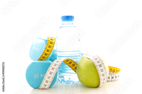diet food concept- dumbbell, water bottle and apple