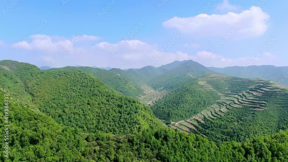 Aerial view of green mountains and nice terraces under blue sky and white clouds Aerial view of green mountains and nice terraces under blue sky and white clouds