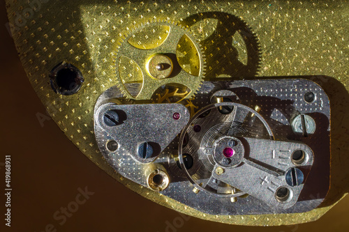 Close-up of the clock mechanism. Gears and balancer in old mechanical watches. Rough textures of metals. 